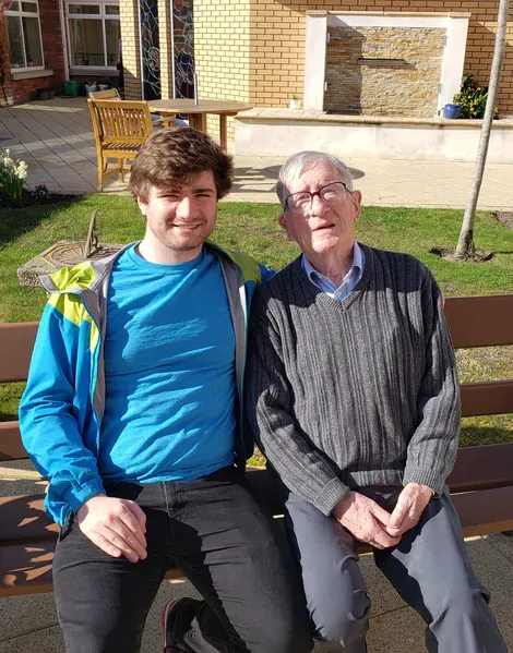 A picture of Oscar and his grandfather outside on a bench in Ireland